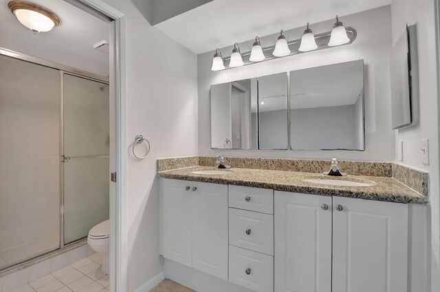 full bathroom featuring a sink, tile patterned flooring, a stall shower, and toilet