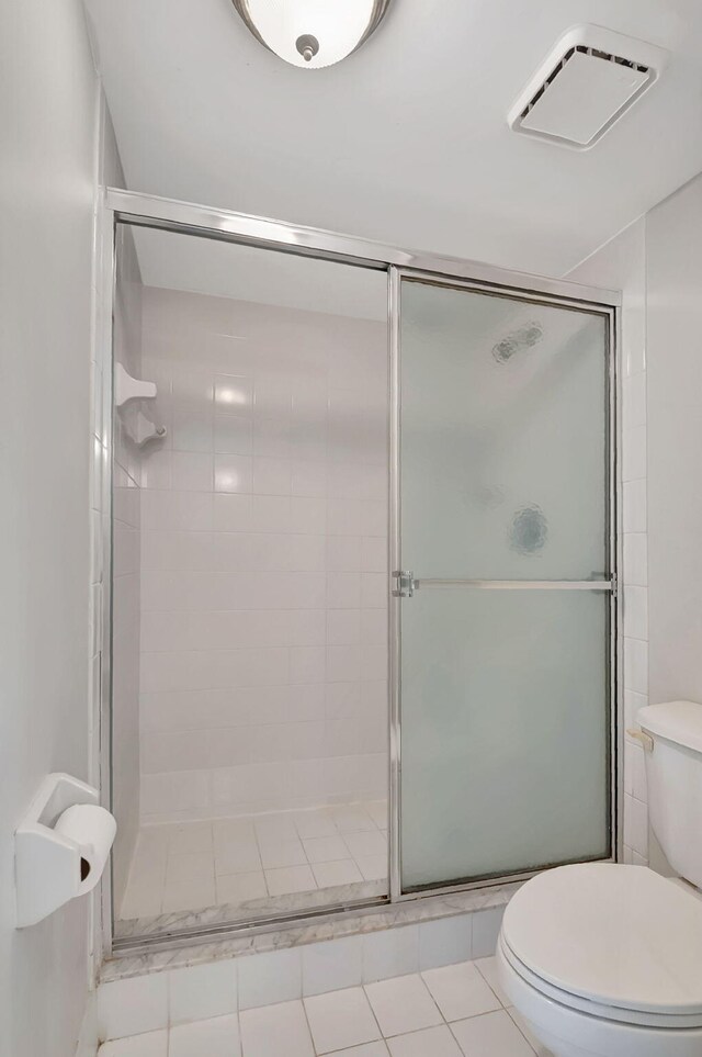 bathroom featuring a stall shower, toilet, and visible vents