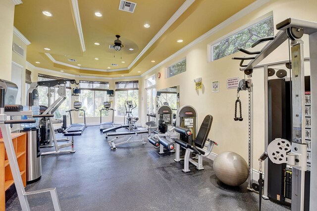 exercise room featuring visible vents, crown molding, a tray ceiling, and ceiling fan