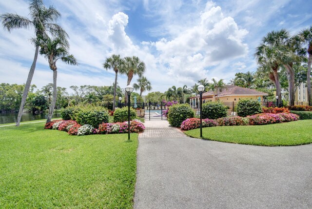 view of home's community featuring fence, a gate, and a yard