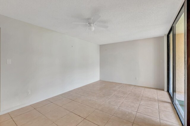 unfurnished room with a textured ceiling, ceiling fan, and light tile patterned floors