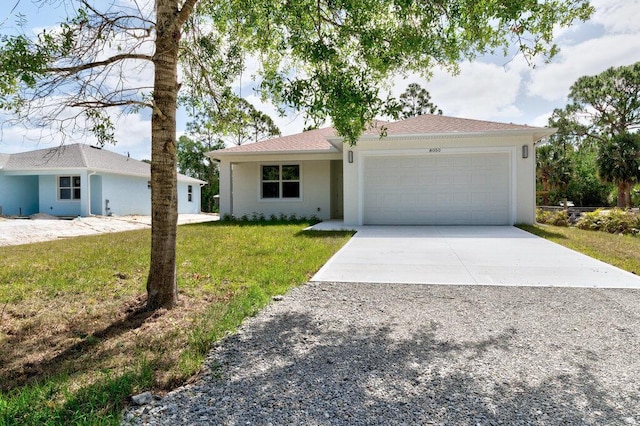 ranch-style home featuring a garage, stucco siding, driveway, and a front yard