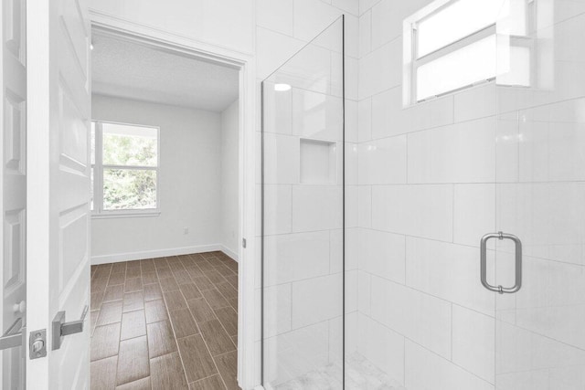 bathroom with baseboards and a stall shower