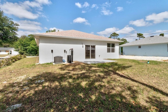 rear view of house featuring a lawn, a patio area, and stucco siding
