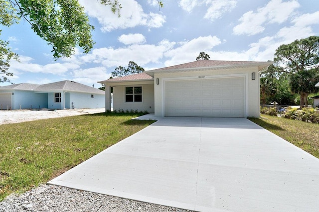 ranch-style house with a garage, stucco siding, driveway, and a front yard