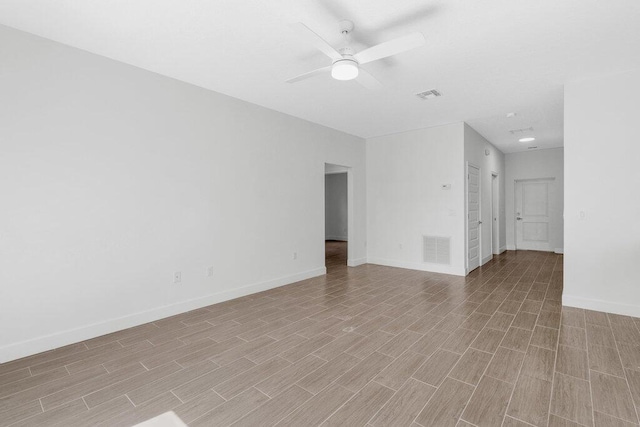 empty room featuring baseboards, ceiling fan, light wood finished floors, and visible vents