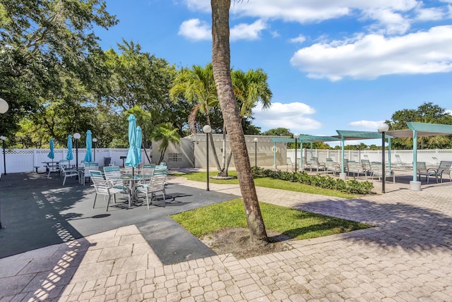 surrounding community featuring fence and outdoor dining space