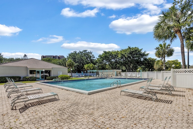 pool featuring fence and a patio area