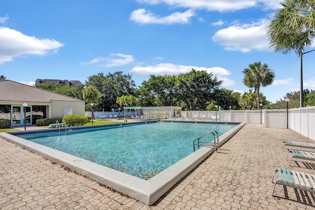 pool with a patio and fence
