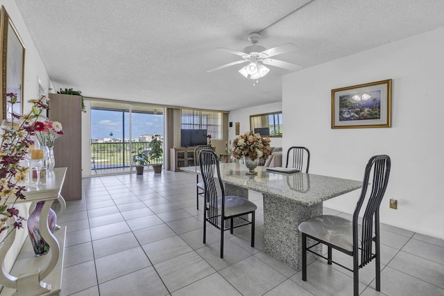 dining area with a ceiling fan, a textured ceiling, and light tile patterned floors