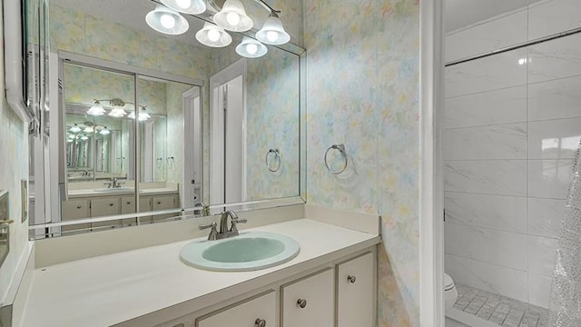 full bath with toilet, wallpapered walls, a chandelier, and a sink