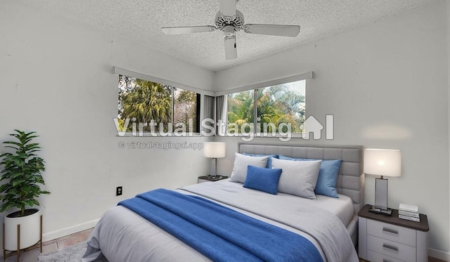 bedroom with baseboards, a ceiling fan, and a textured ceiling