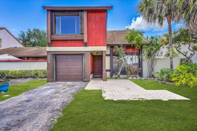 view of front of property featuring driveway, a front yard, and a garage