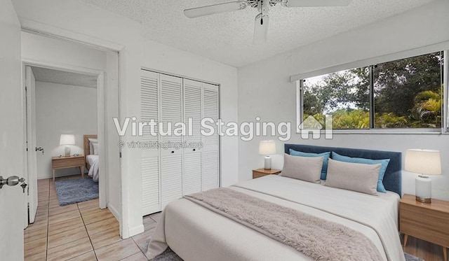 bedroom with a closet, a textured ceiling, ceiling fan, and light tile patterned floors