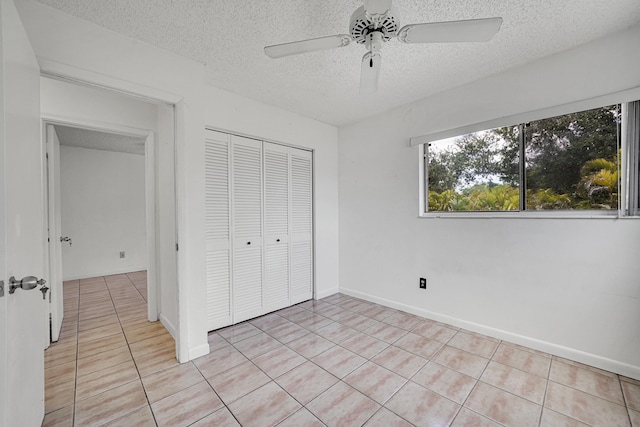 unfurnished bedroom featuring a closet, a textured ceiling, ceiling fan, and light tile patterned floors