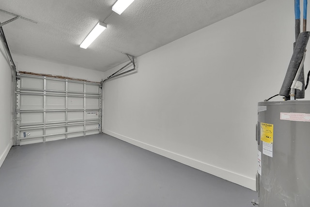 garage featuring baseboards and electric water heater