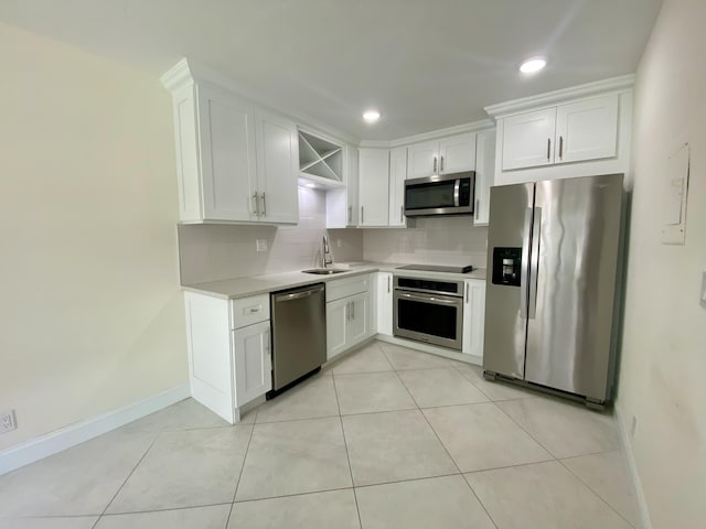 kitchen featuring white cabinets, a sink, light countertops, stainless steel appliances, and decorative backsplash