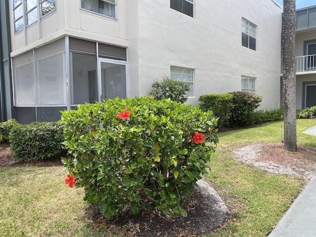 view of side of home with a lawn and stucco siding