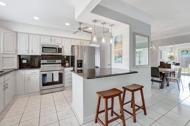 1065 SW 13th St, Boca Raton, FL 33486 - kitchen with dark countertops, a ceiling fan, stainless steel appliances, and backsplash