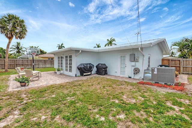 1065 SW 13th St, Boca Raton, FL 33486 - rear view of property with stucco siding, a fenced backyard, central AC unit, french doors, and a patio