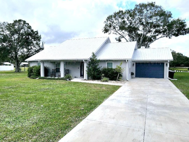 603 NW 11th Ave, Okeechobee, FL 34972 - view of front of home with concrete driveway, an attached garage, metal roof, and a front lawn