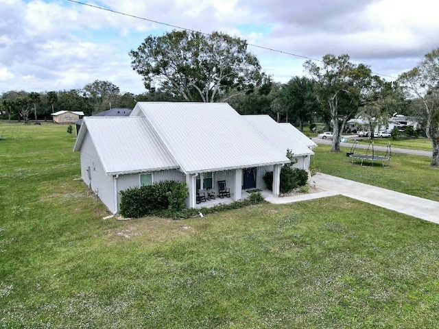 603 NW 11th Ave, Okeechobee, FL 34972 - exterior space with a lawn, a trampoline, and metal roof