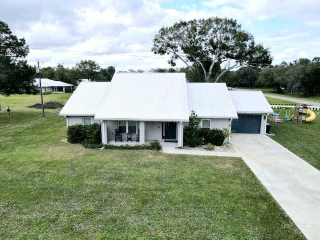 603 NW 11th Ave, Okeechobee, FL 34972 - view of front of home with an attached garage, driveway, a front yard, and a porch