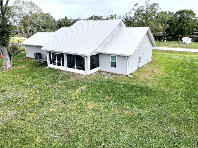 603 NW 11th Ave, Okeechobee, FL 34972 - rear view of house with a sunroom and a yard