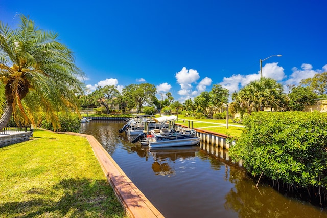 1501 NE 13th Ter Unit H-9, Jensen Beach, FL 34957 - view of dock featuring a lawn and a water view