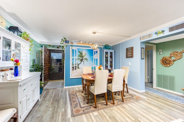 1501 NE 13th Ter Unit H-9, Jensen Beach, FL 34957 - dining area featuring an inviting chandelier, ornamental molding, and visible vents
