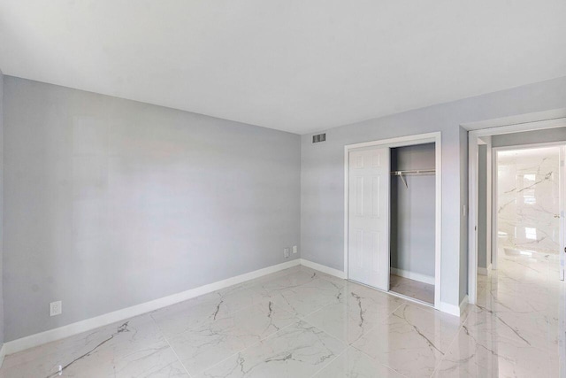 9960 Pineapple Tree Dr Unit 107, Boynton Beach, FL 33436 - unfurnished bedroom featuring baseboards, visible vents, marble finish floor, and a closet