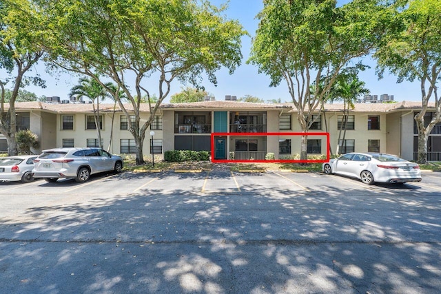 9960 Pineapple Tree Dr Unit 107, Boynton Beach, FL 33436 - view of front of home featuring a chimney, uncovered parking, and stucco siding