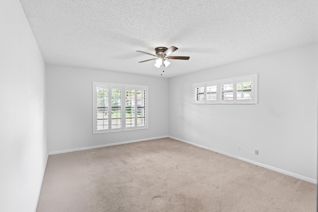 carpeted spare room with baseboards, a textured ceiling, and ceiling fan
