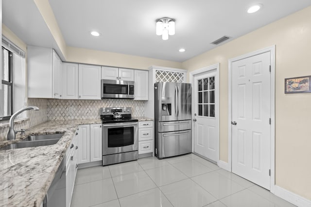 kitchen featuring visible vents, a sink, white cabinets, and stainless steel appliances