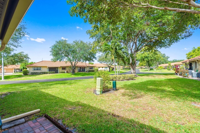 view of yard featuring central AC and a residential view