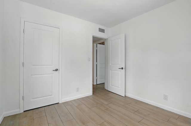 unfurnished bedroom featuring baseboards, visible vents, and light wood-style flooring