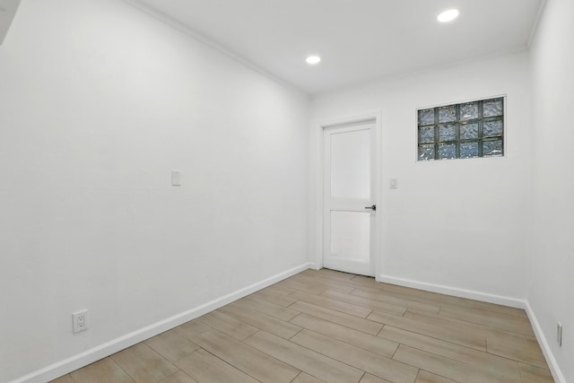 spare room featuring recessed lighting, baseboards, and light wood finished floors