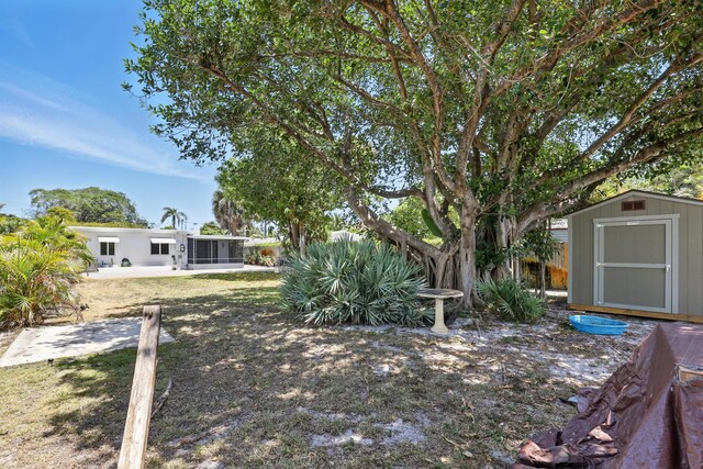 1225 15th Ave N, Lake Worth Beach, FL 33460 - view of yard featuring a storage unit, an outbuilding, and a sunroom