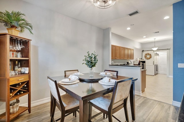 dining area featuring light wood finished floors, baseboards, and recessed lighting