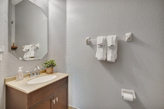 bathroom featuring vanity and a textured wall