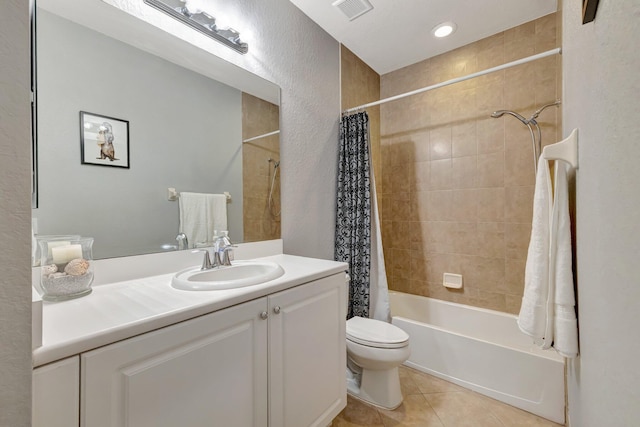 bathroom featuring tile patterned flooring, toilet, shower / bath combo with shower curtain, vanity, and a textured wall