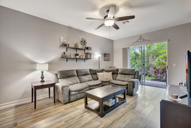 living room with ceiling fan, light wood finished floors, and baseboards