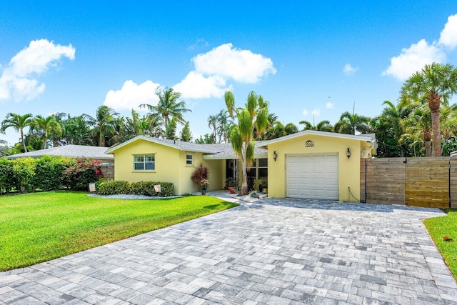 2701 SW 4th St, Boynton Beach, FL 33435 - view of front of house featuring a front yard, decorative driveway, fence, an attached garage, and stucco siding