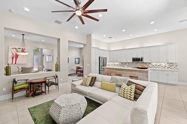 living area with a ceiling fan, visible vents, baseboards, recessed lighting, and light tile patterned flooring