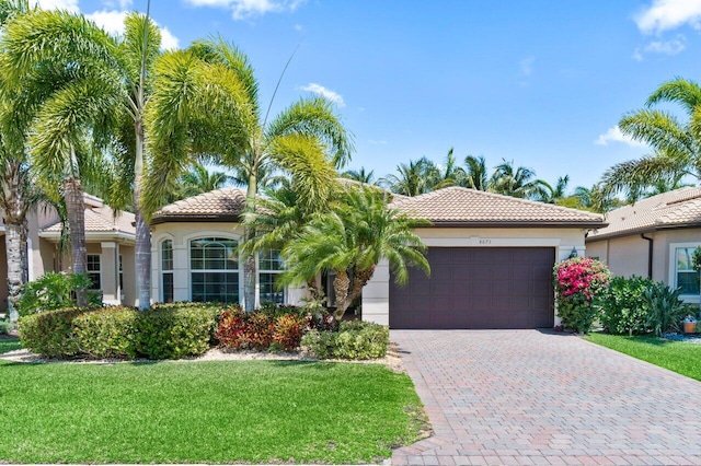 8673 Carmel Mountain Way, Boynton Beach, FL 33473 - mediterranean / spanish-style house featuring an attached garage, a tile roof, a front lawn, and stucco siding