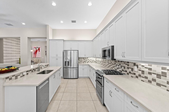 8673 Carmel Mountain Way, Boynton Beach, FL 33473 - kitchen with appliances with stainless steel finishes, a sink, light tile patterned flooring, tasteful backsplash, and light countertops