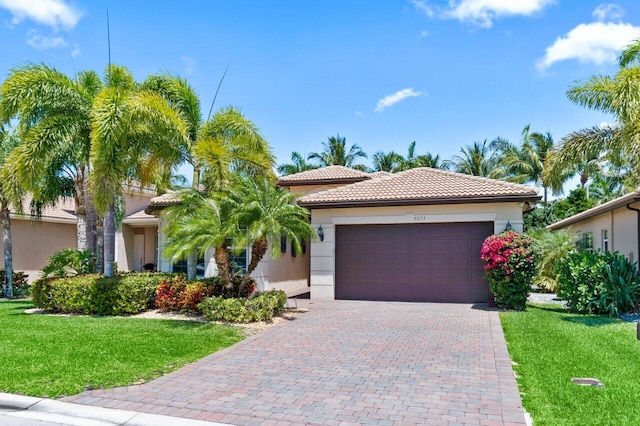 8673 Carmel Mountain Way, Boynton Beach, FL 33473 - mediterranean / spanish-style house with a garage, a tiled roof, a front lawn, stucco siding, and decorative driveway