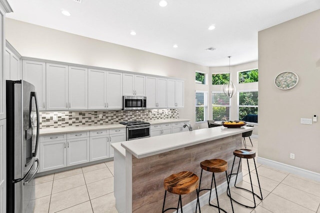 8673 Carmel Mountain Way, Boynton Beach, FL 33473 - kitchen featuring stainless steel appliances, tasteful backsplash, light tile patterned floors, and recessed lighting