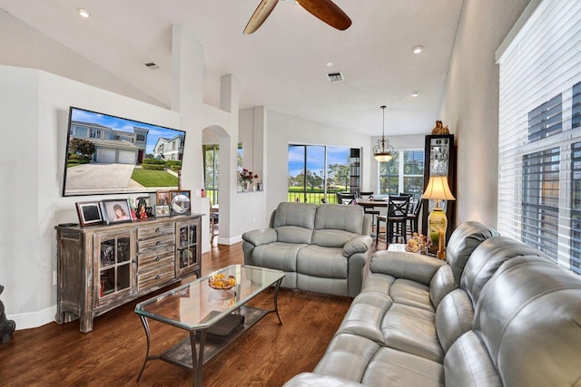 living area with vaulted ceiling, arched walkways, wood finished floors, ceiling fan, and baseboards