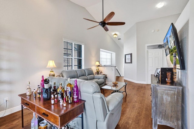 living room with ceiling fan, wood finished floors, baseboards, and high vaulted ceiling